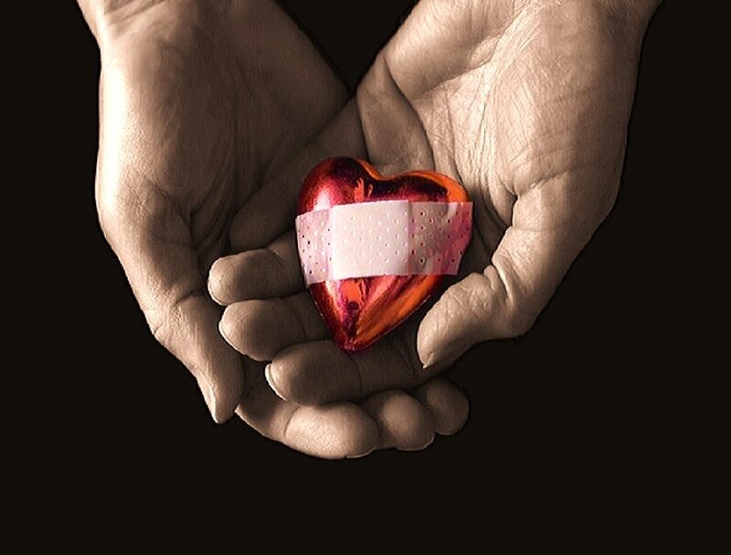 hands holding a bandaged heart