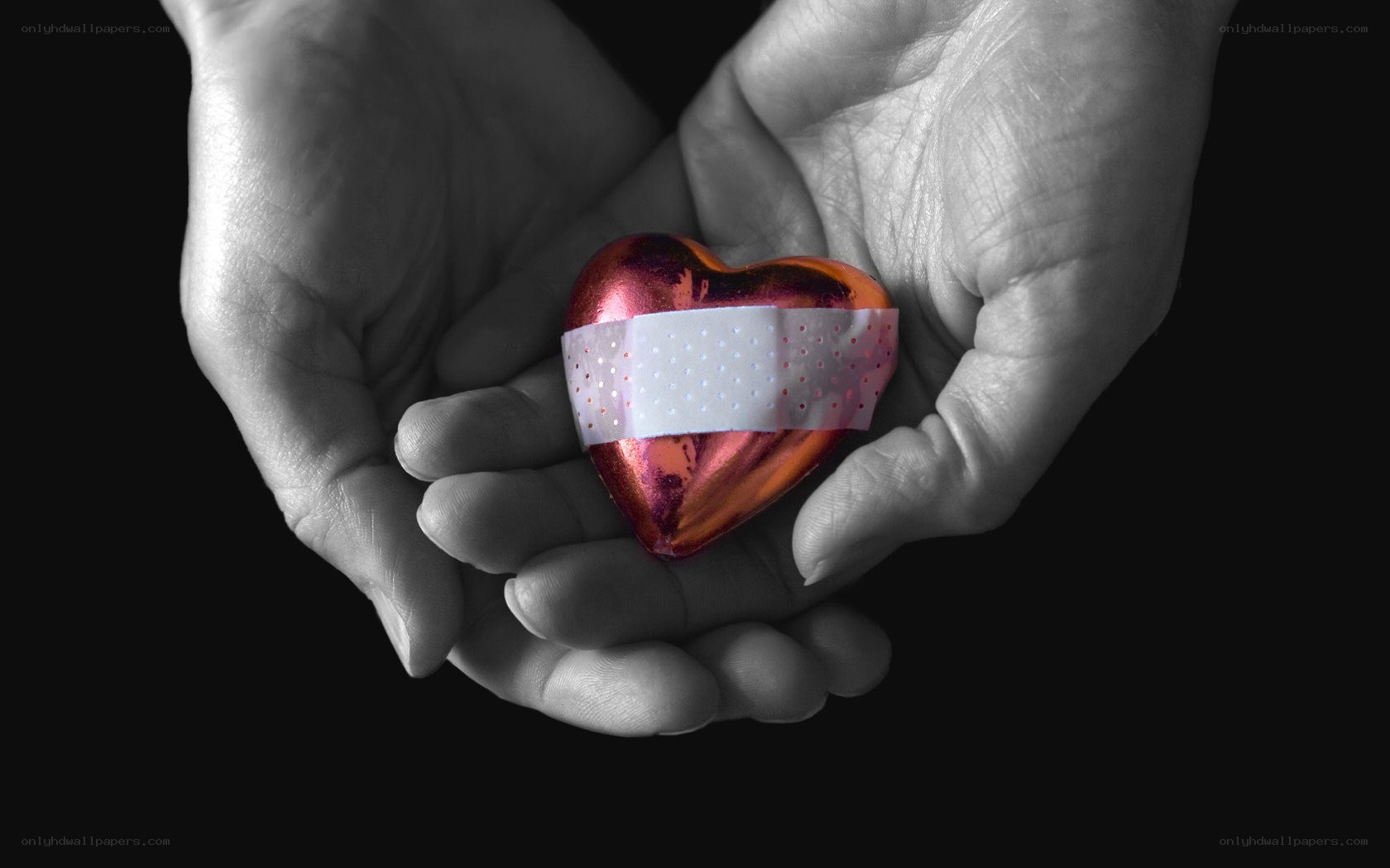 hands holding a bandaged heart