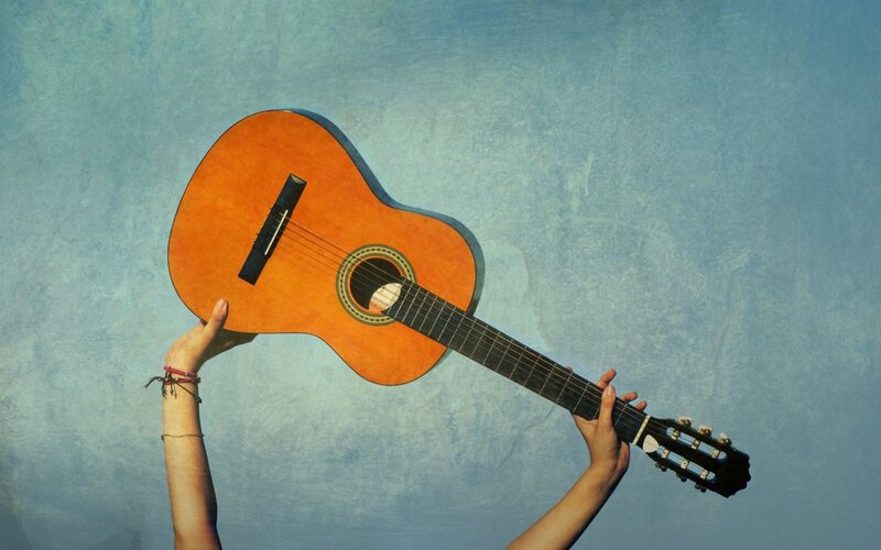 Hands holding a classical guitar