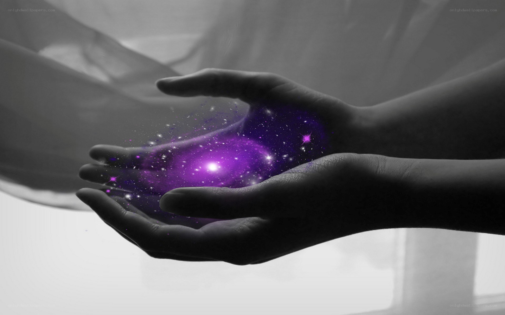 hands holding a galaxy