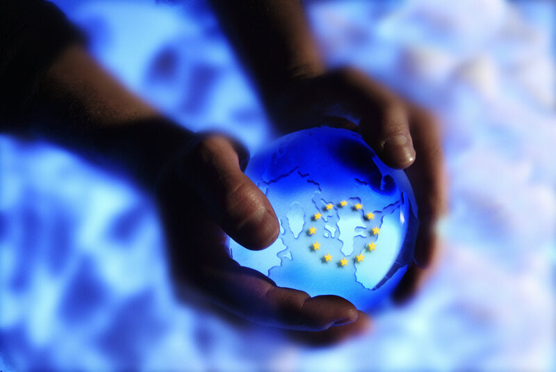 hands holding a glowing globe