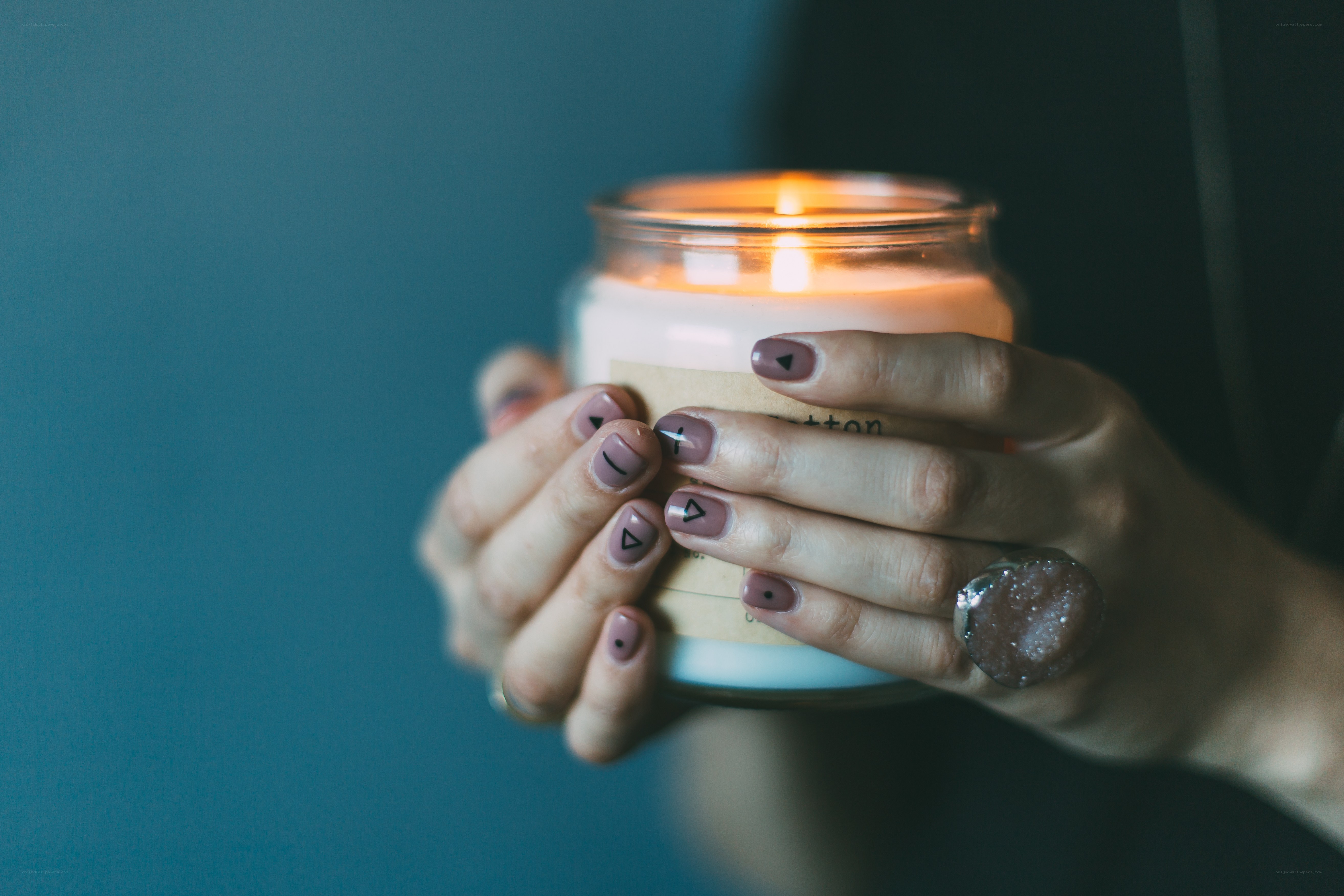 hands holding a lit candle