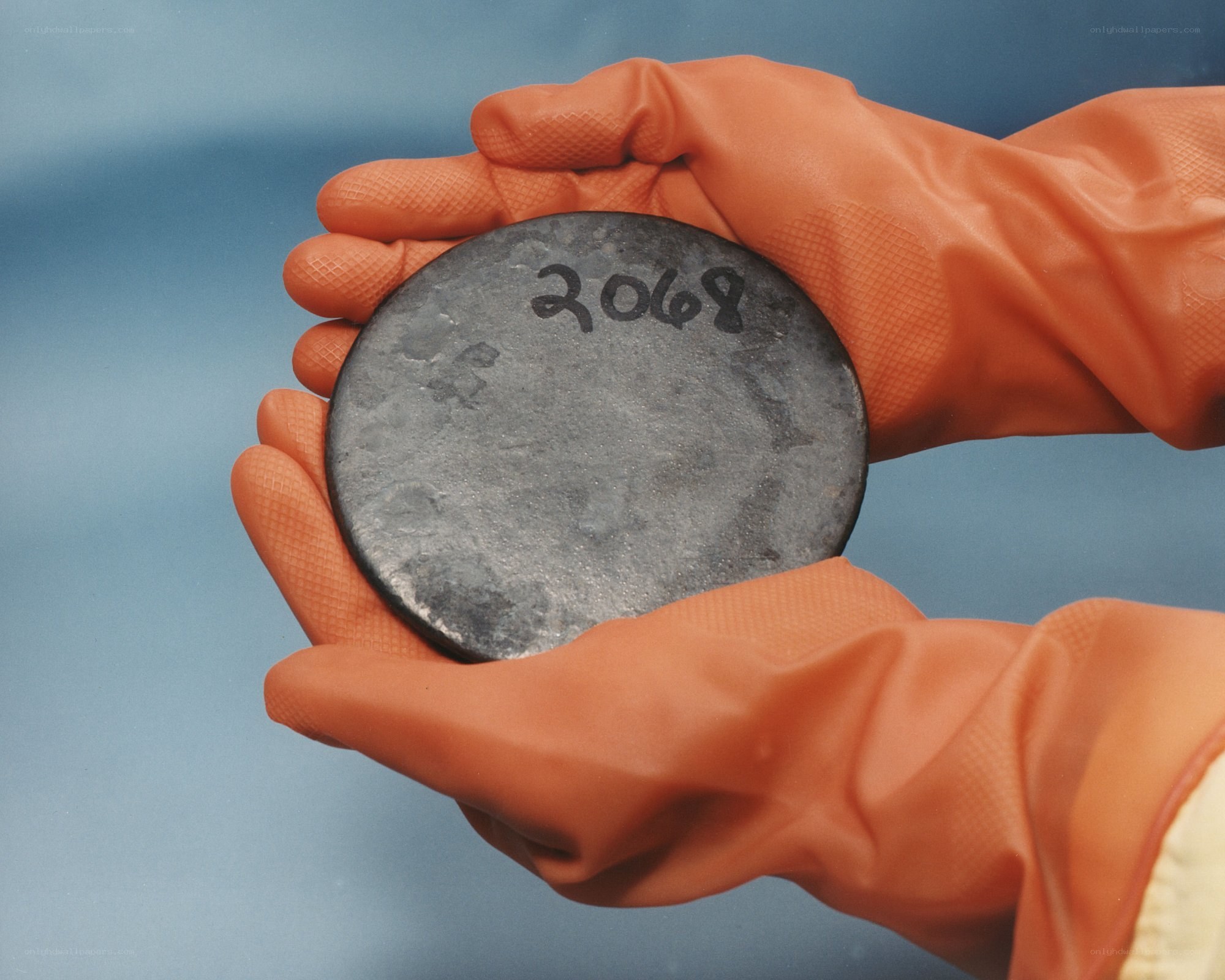 hands holding a metal disc