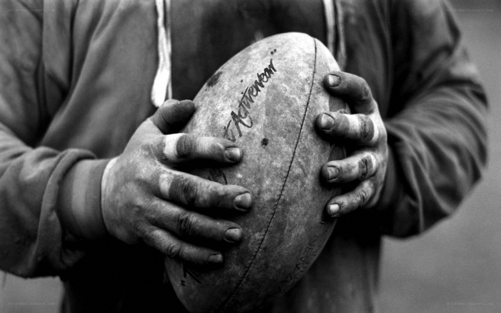 hands holding a rugby ball