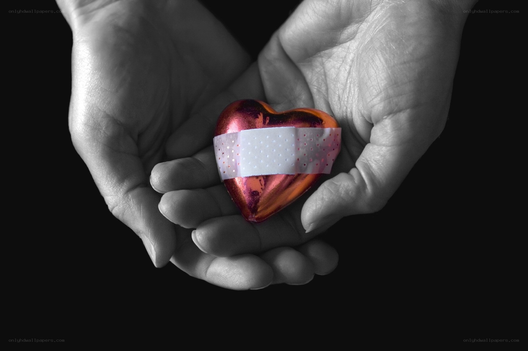 hands holding bandaged heart