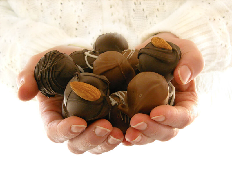 Hands Holding Chocolate Truffles
