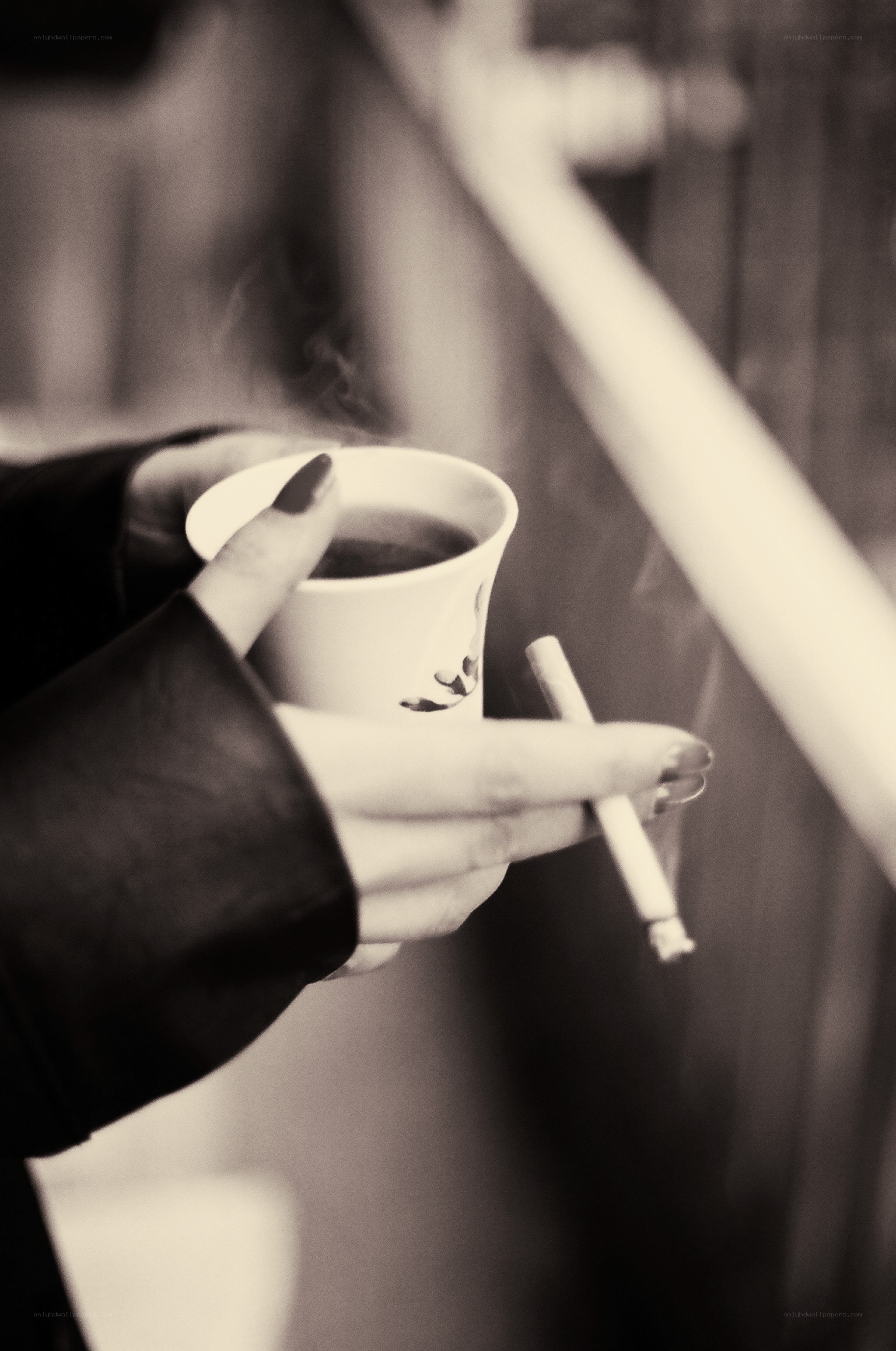 Hands holding coffee and cigarette