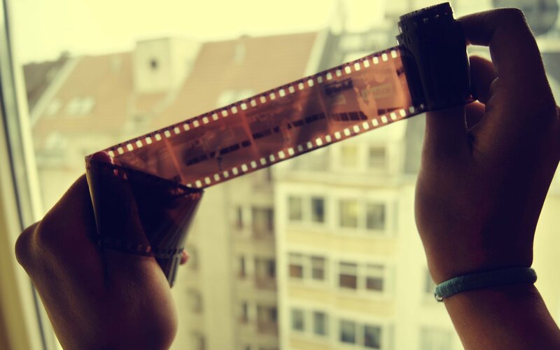 Hands Holding Film Strip — Brown