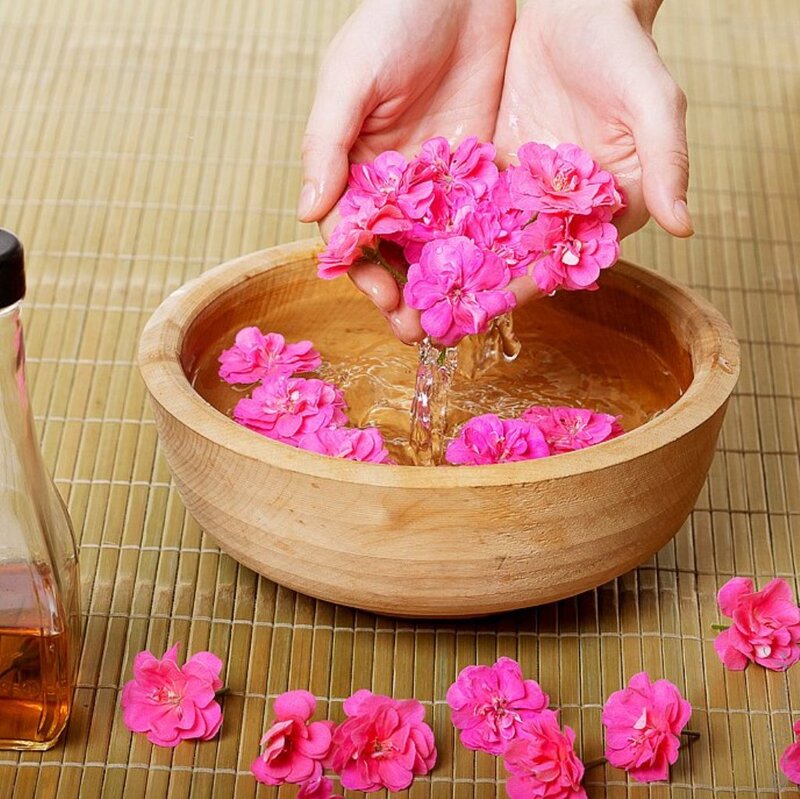 Hands Holding Flowers over Bowl