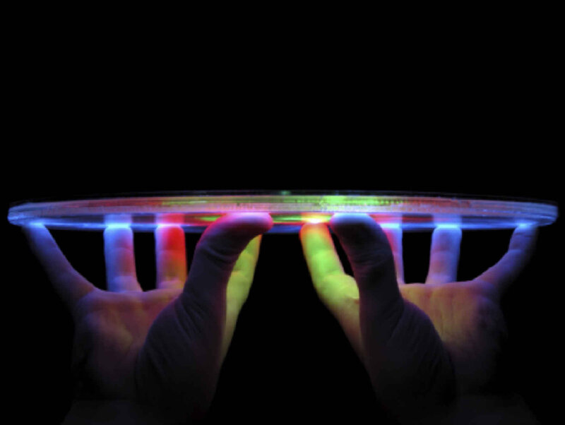 hands holding glowing disc