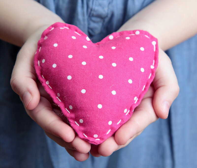 Hands Holding Heart Pillow
