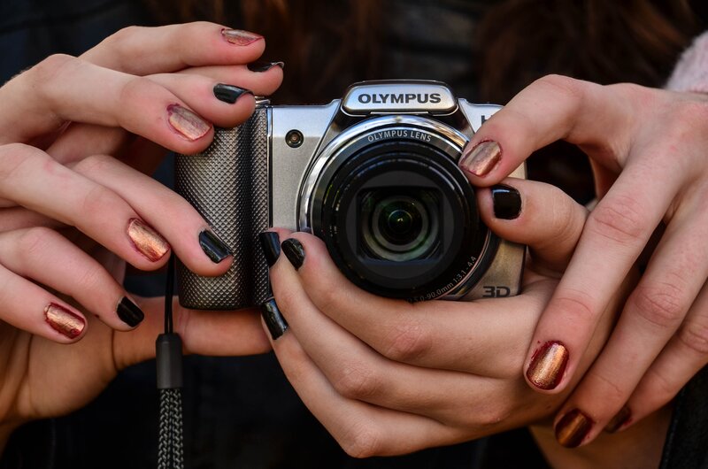 Hands holding Olympus camera