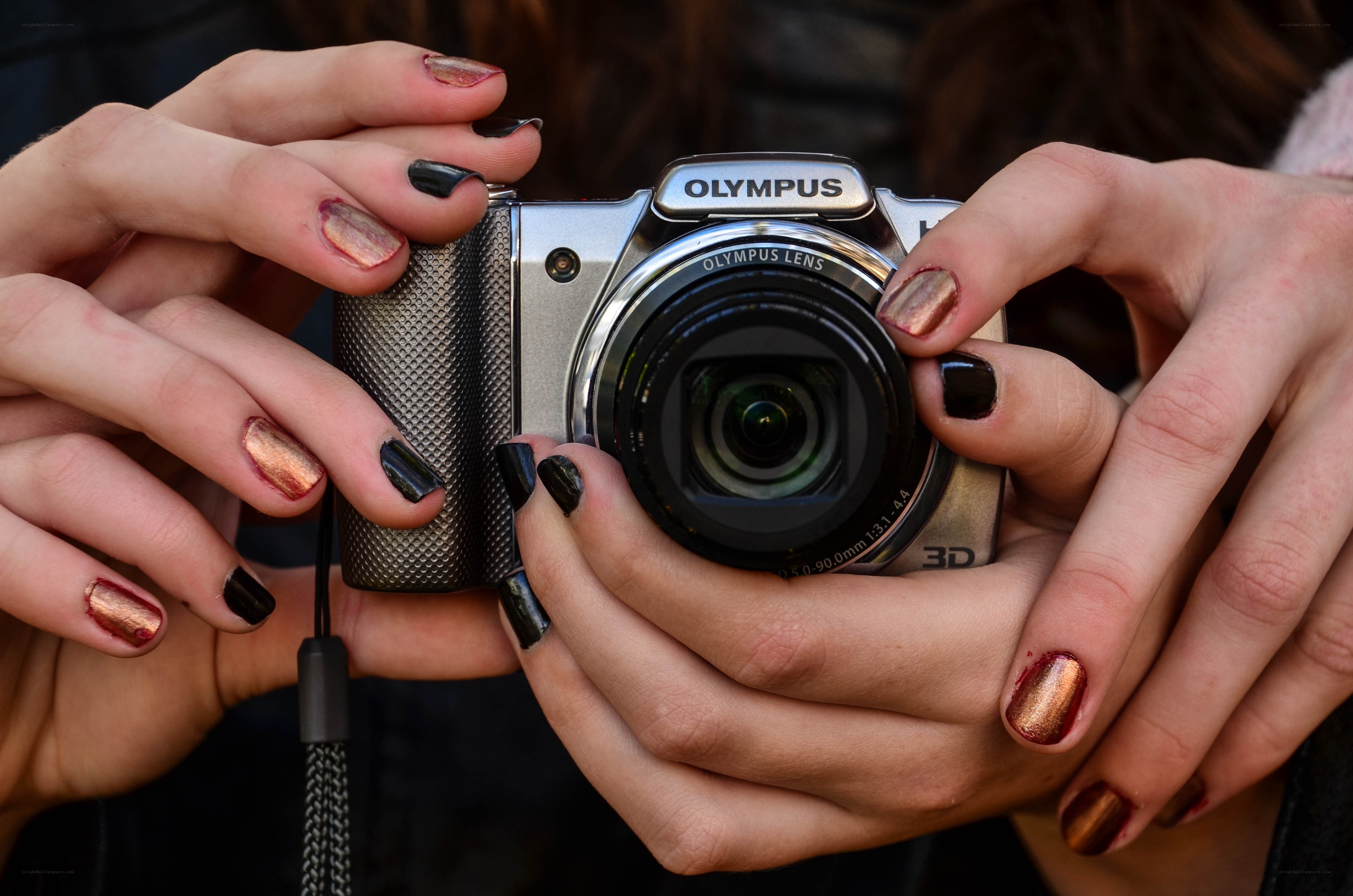 Hands holding Olympus camera