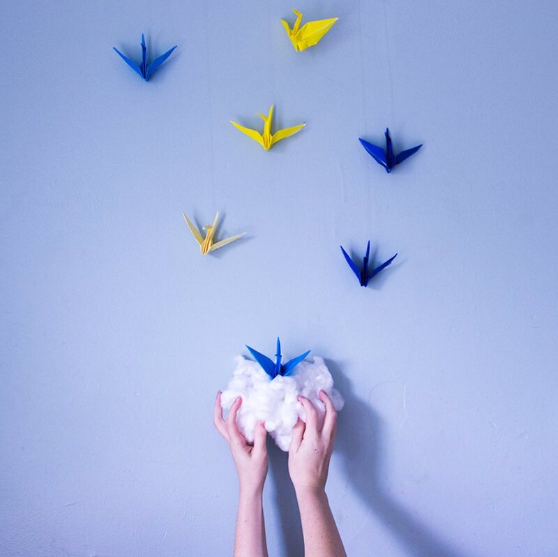 Hands Holding Origami Cranes