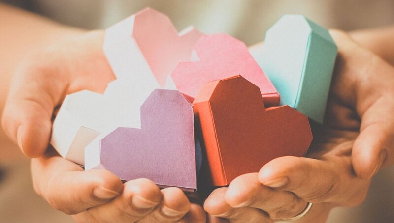 Hands Holding Paper Hearts — White