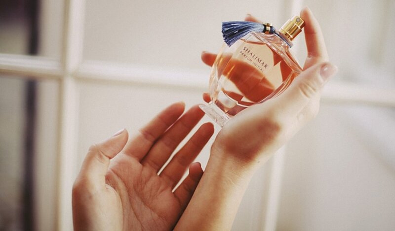 hands holding perfume bottle
