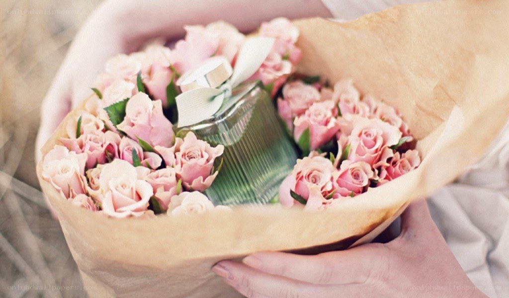 hands holding roses and perfume