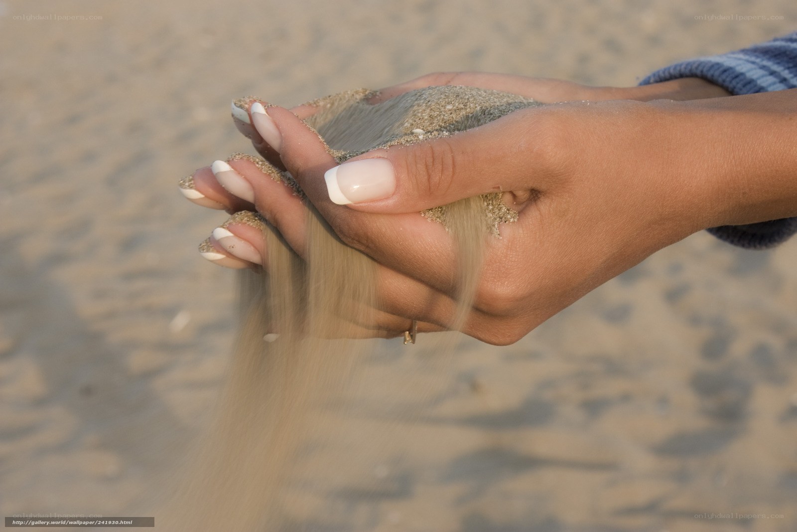 hands holding sand at beach