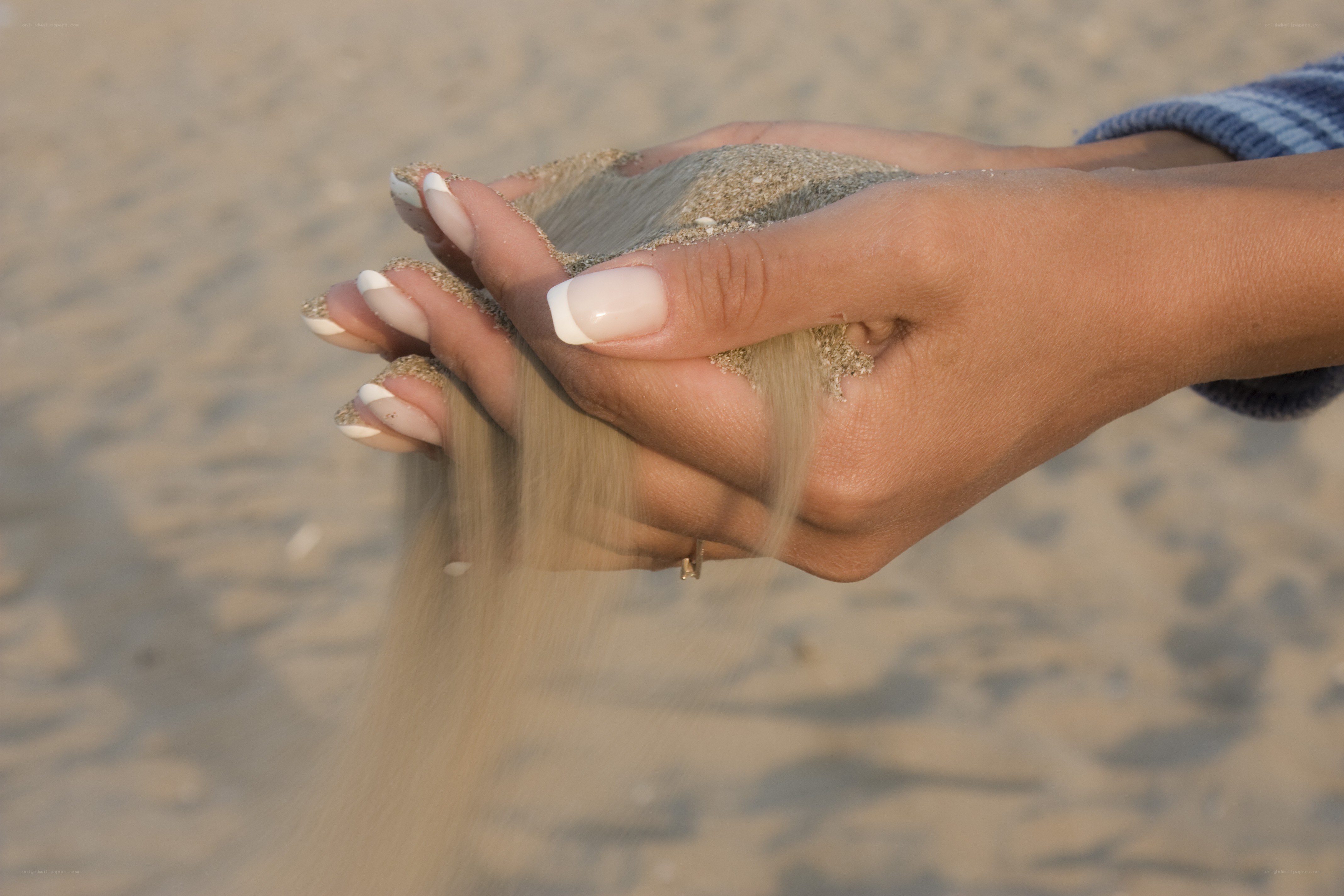 hands holding sand at beach
