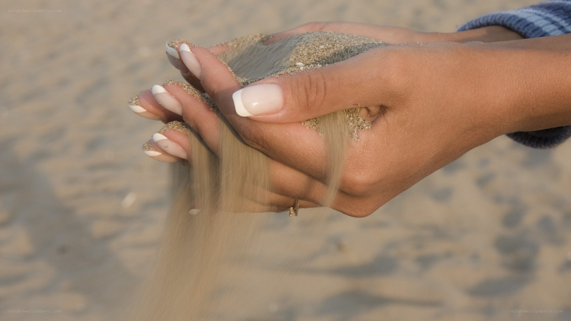 hands holding sand at beach