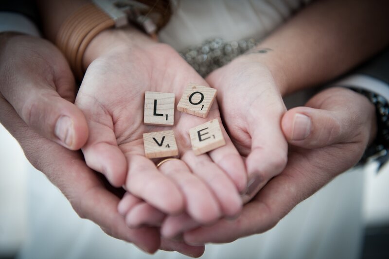 Hands Holding Scrabble Tiles — White