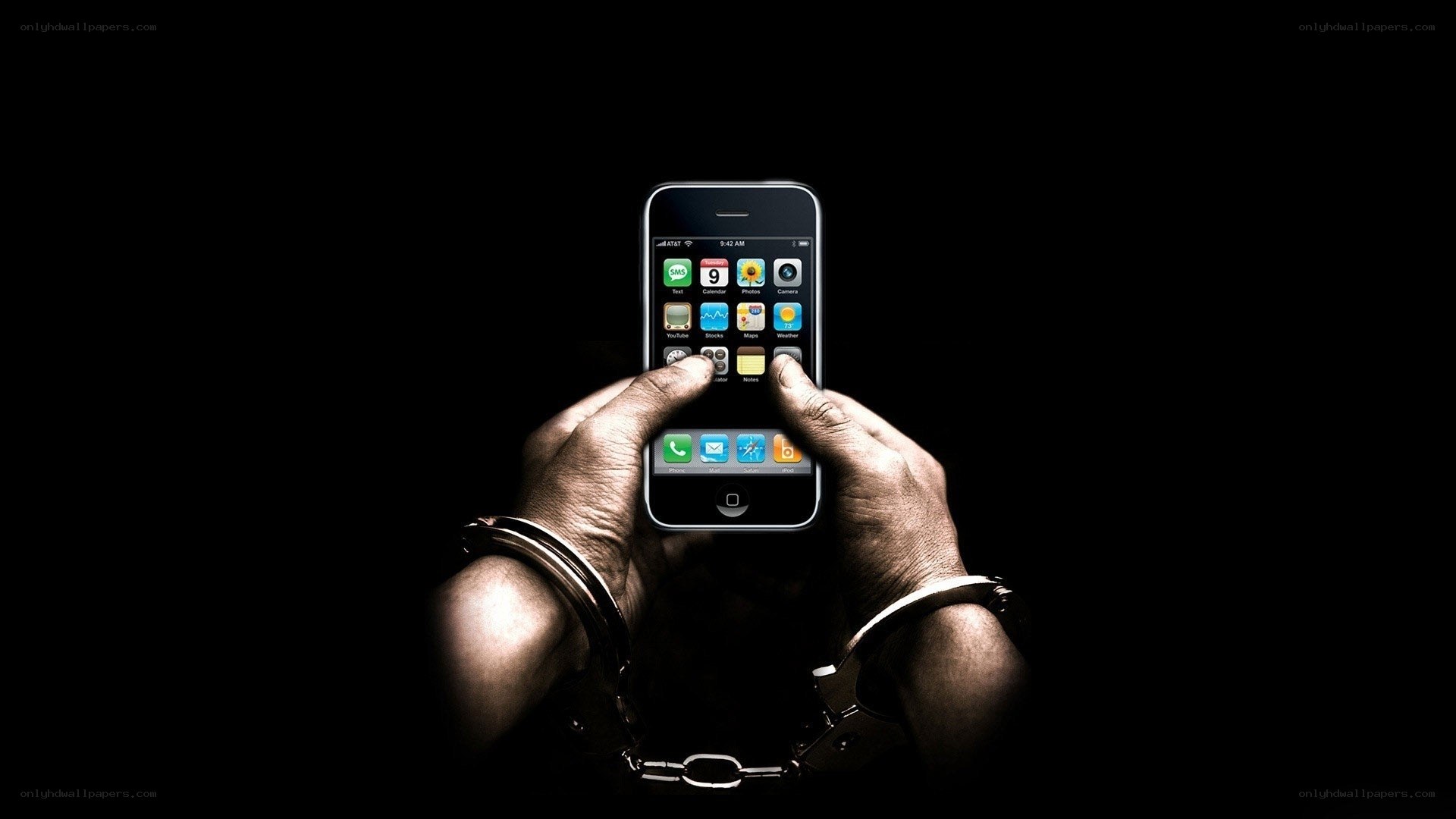 Hands holding smartphone in handcuffs