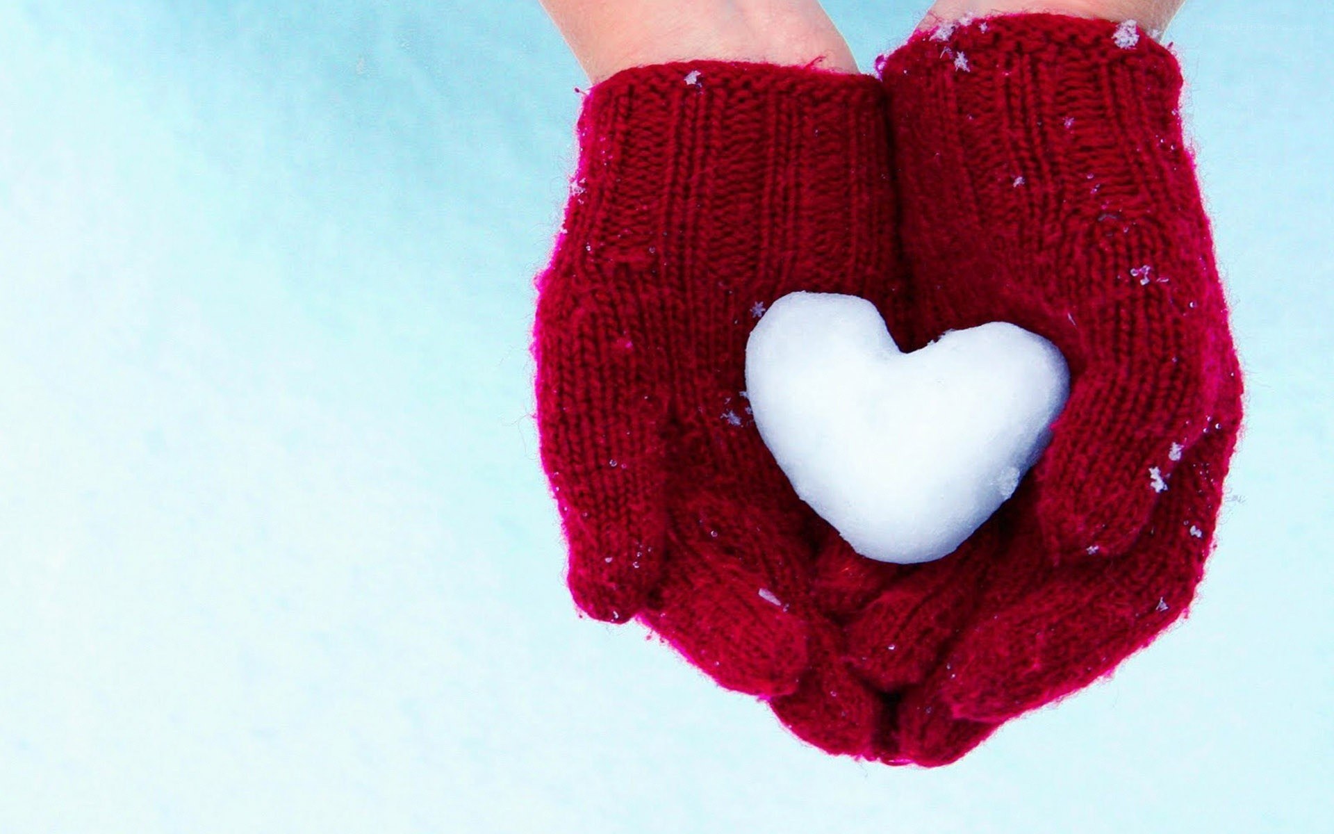 hands holding snow heart