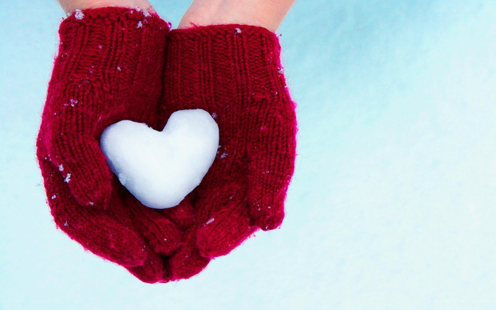 hands holding snow heart
