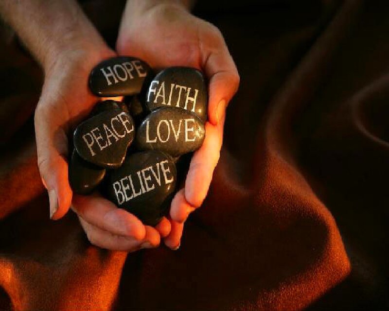hands holding stones with words