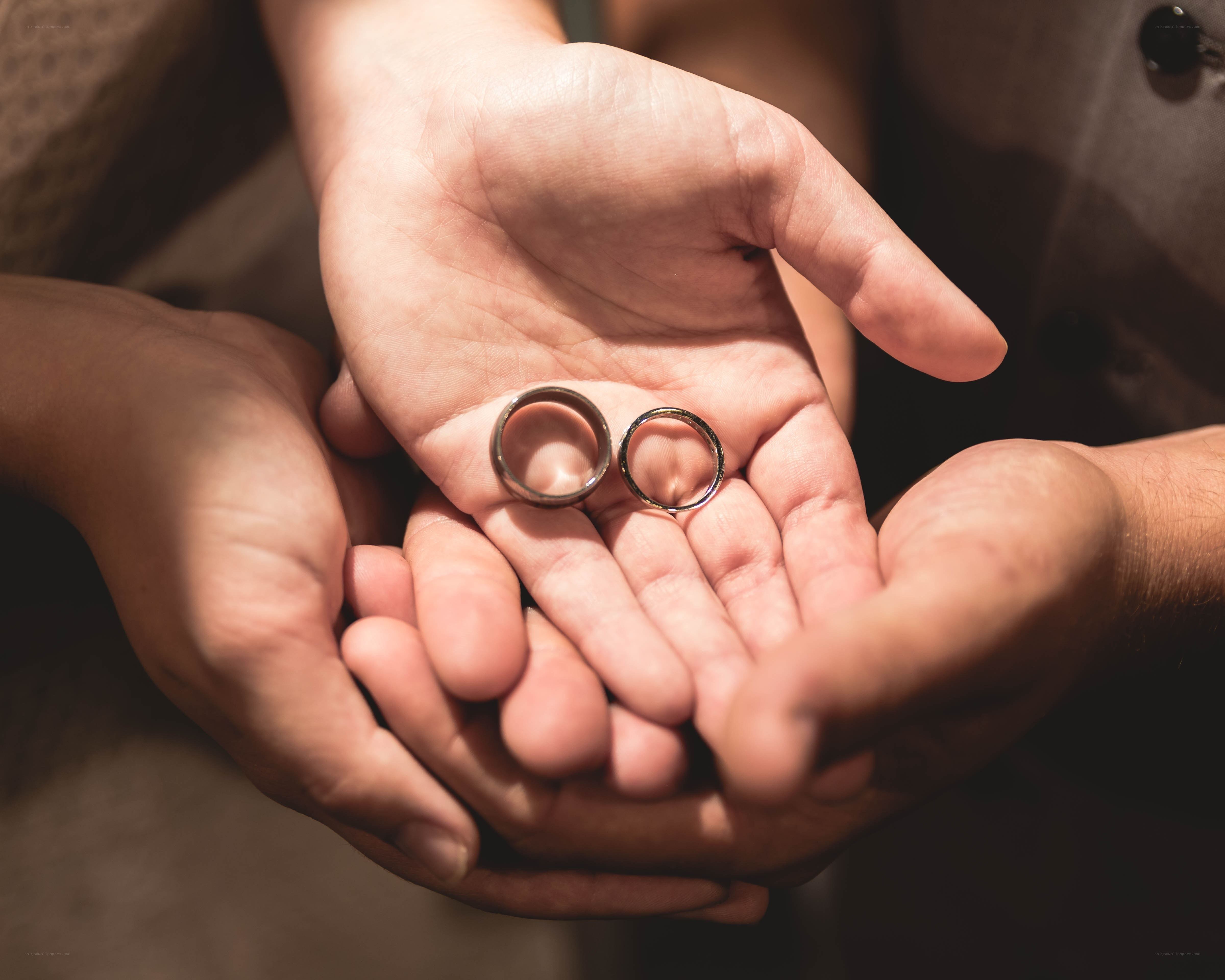 hands holding wedding rings