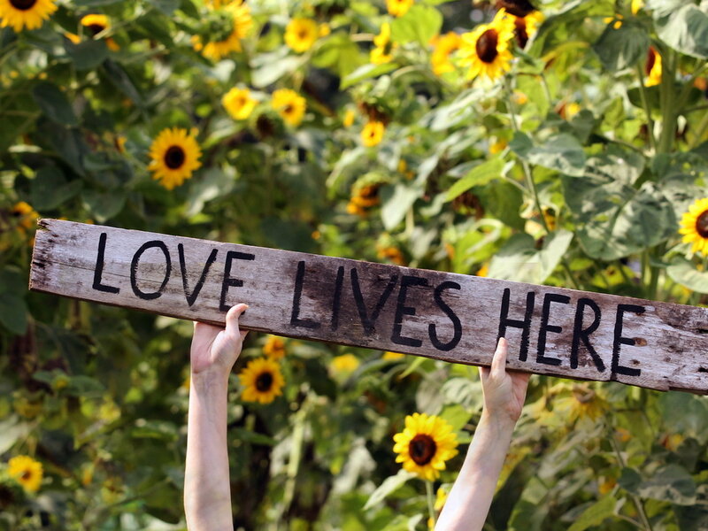 Hands Holding Wooden Sign