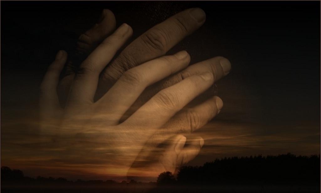 hands in prayer at sunset