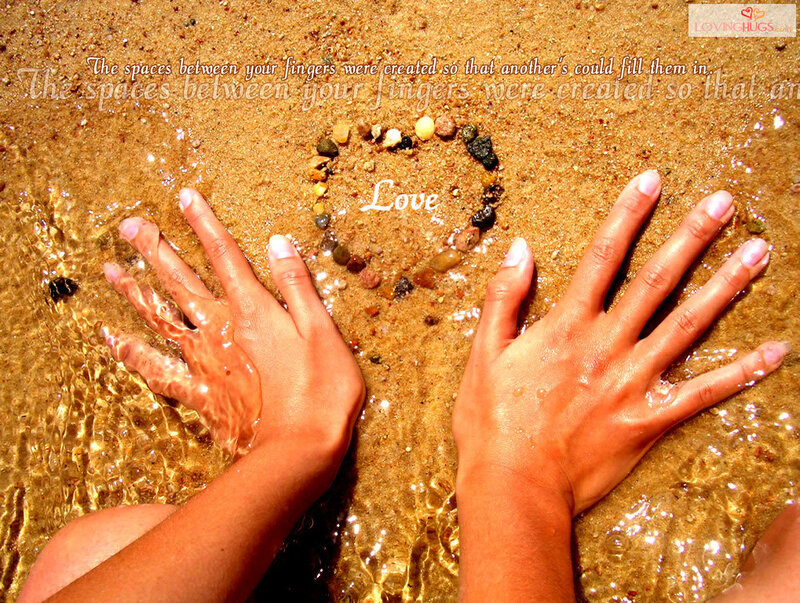 Hands on beach with heart