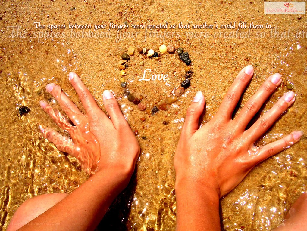 Hands on beach with heart
