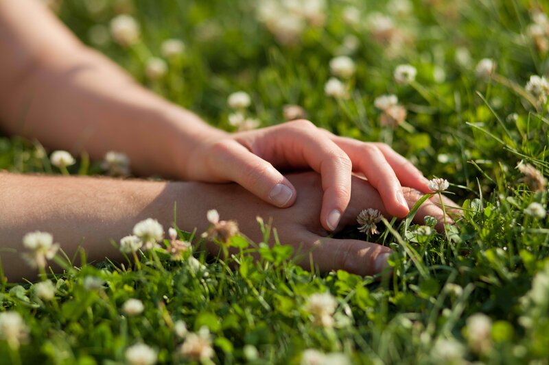 hands on grass in sunlight