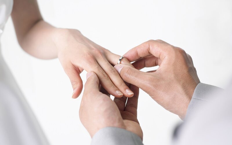 Hands Placing Ring on Finger