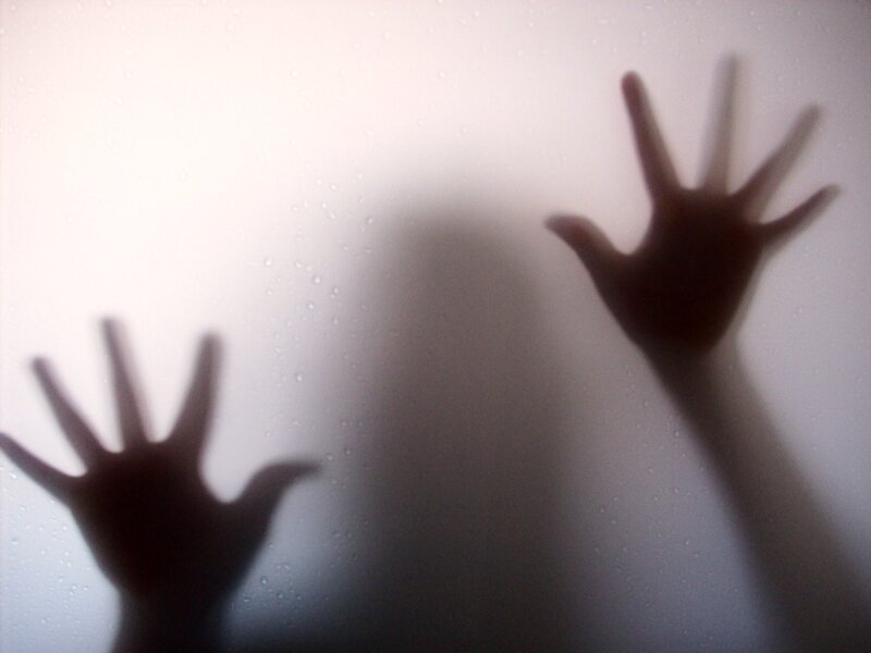 hands pressed against frosted glass