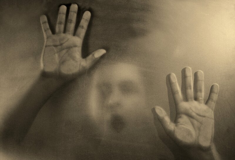 hands pressed against glass