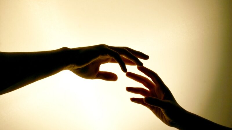 hands reaching in silhouette