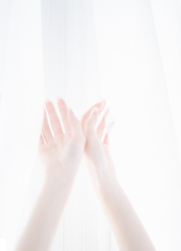 hands reaching through sheer fabric