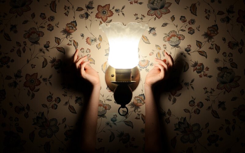 Hands Reaching Toward Lamp