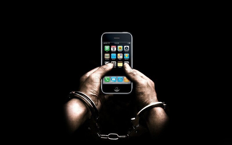 hands with handcuffs holding smartphone