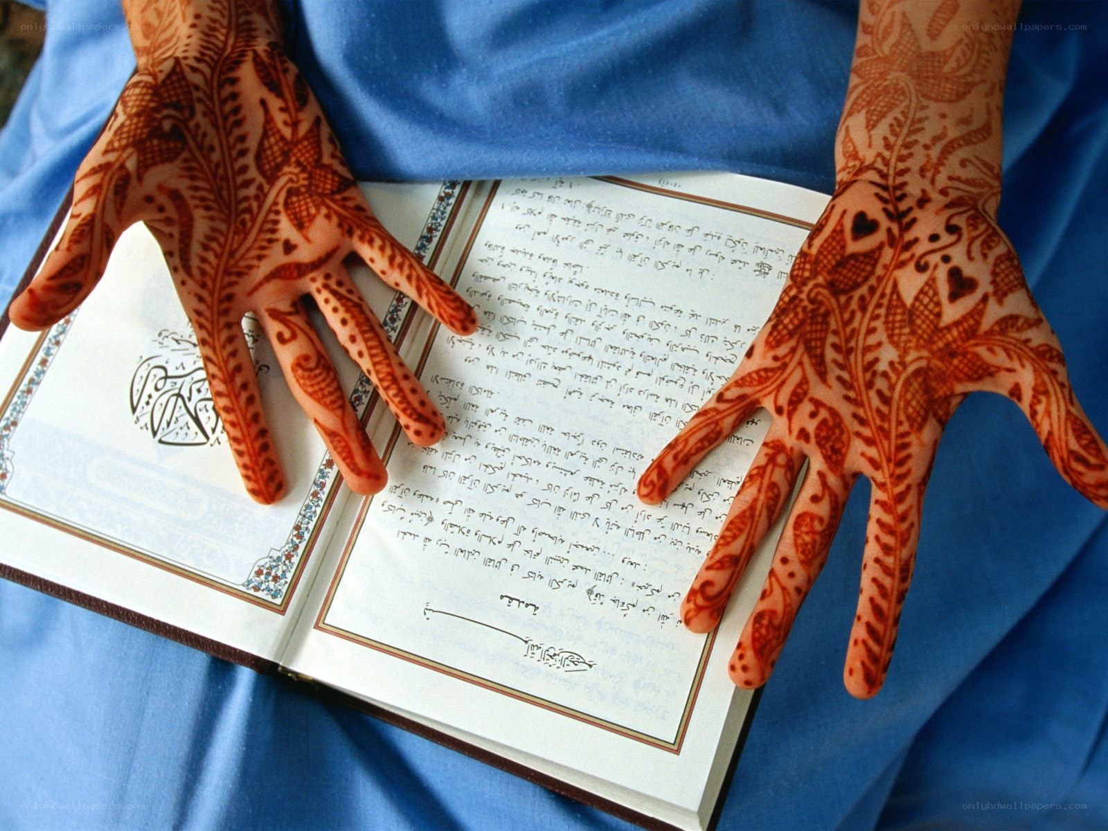 Hands with henna over a book