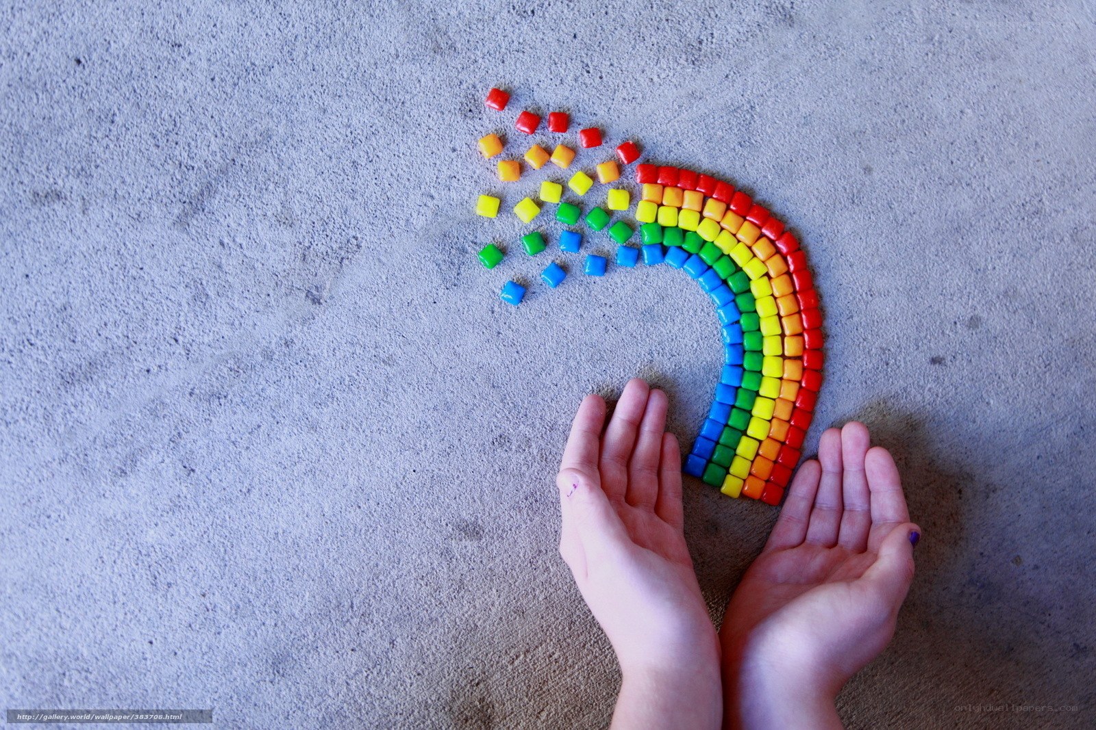 hands with rainbow candy