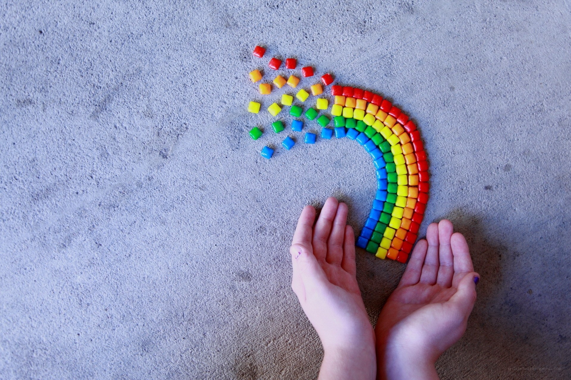 hands with rainbow candy