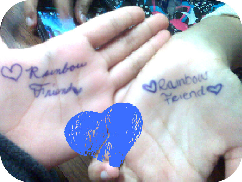 hands with rainbow friend writing