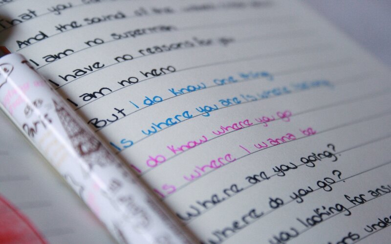 Handwritten lyrics in a notebook
