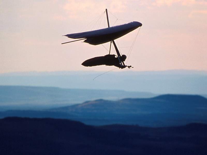 Hang glider in flight at dusk