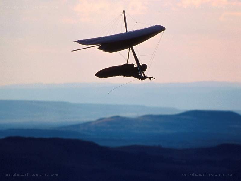 Hang glider in flight at dusk