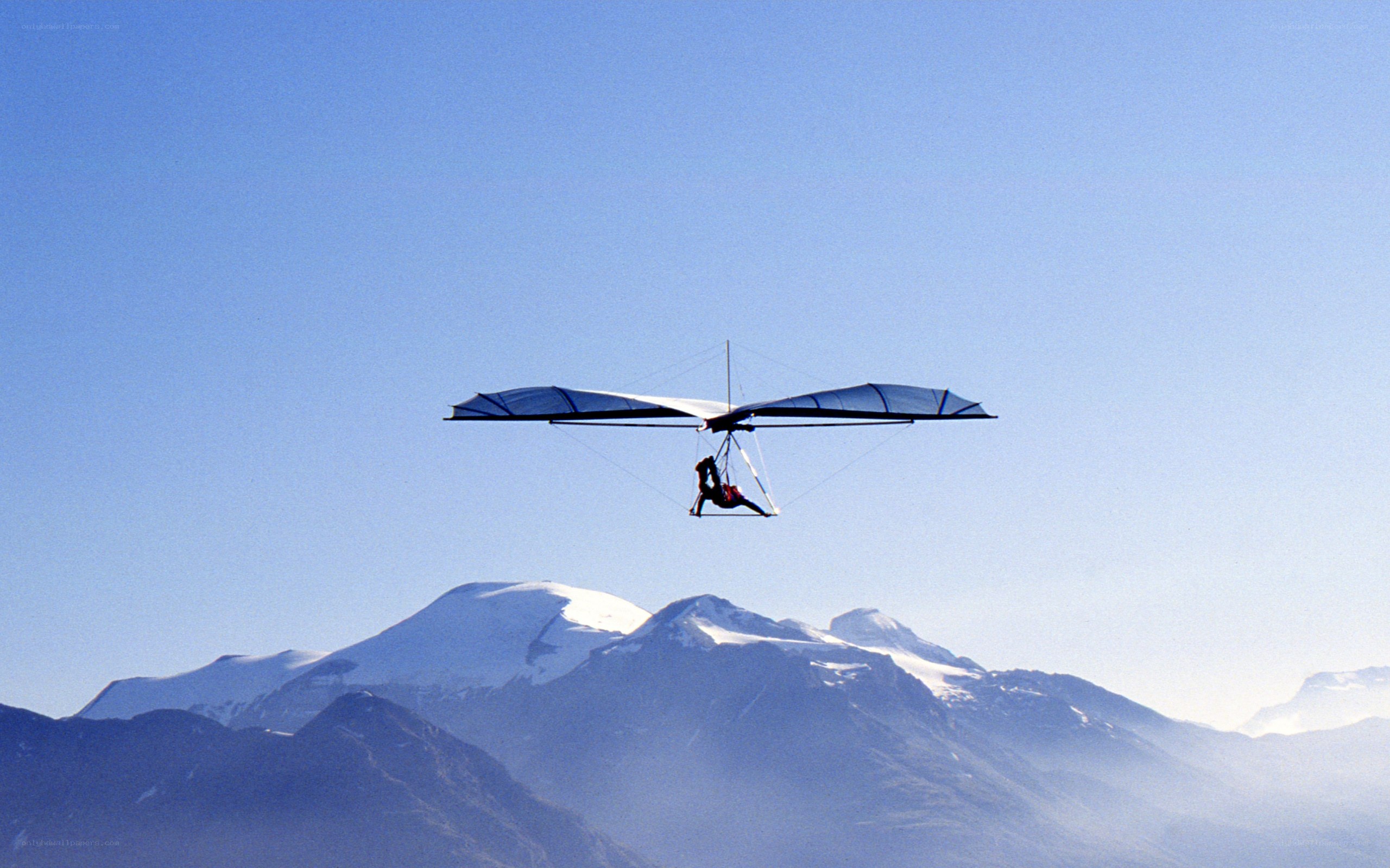 Hang glider over snow-capped mountains